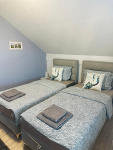 two beds sitting next to each other in a room at Apartman Feniks in Sjenica