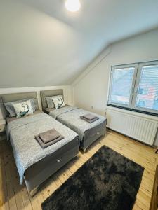 a bedroom with two beds and a large window at Apartman Feniks in Sjenica