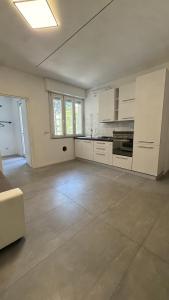 an empty kitchen with white cabinets and appliances in a room at B&B Mavi in Como