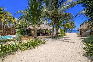 a resort on the beach with palm trees and the ocean at Arenika Beachfront Villa & Rooms in Puerto Morelos +132 photos