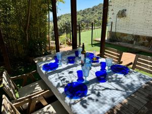 a table with blue plates and glasses on it at Alojamientos COBALTO CASA PARAÍSO in Sant Cebrià de Vallalta