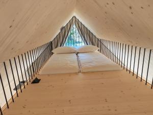 a bed in a loft with a window at Glamp Camp Danica in Bohinj +1 photo