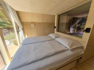 a bed in a small room with a window at Glamp Camp Danica in Bohinj