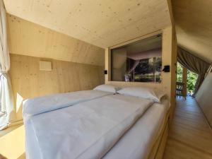 a large bed in a room with a window at Glamp Camp Danica in Bohinj