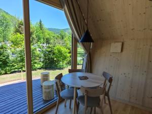 a dining room with a table and chairs and a large window at Glamp Camp Danica in Bohinj