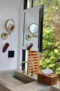 a bathroom with a sink and a mirror on a counter at Cheerful 2 bedroom Villa with Pool in Benque Viejo del Carmen