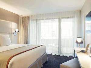 a hotel room with a bed and a large window at Mercure Hotel Golf Cap d'Agde in Cap d'Agde +67 photos