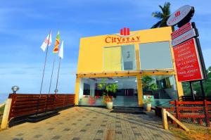 a yellow building with a sign in front of it at City Stay in Galle