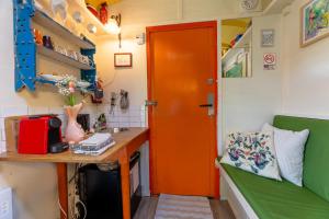 a room with a desk and a red door at Tiny House in Kampen