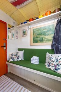 a green bench in a room with a red door at Tiny House in Kampen