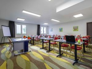 a classroom with tables and red chairs and a screen at ibis Styles Gien in Gien +64 photos
