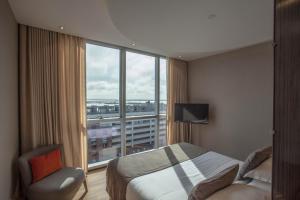 a hotel room with a bed and a large window at Puerto Norte Design Hotel in Rosario