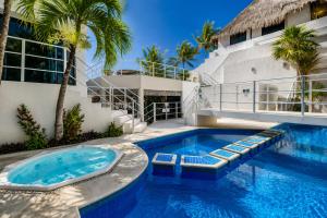 a swimming pool in front of a building with palm trees at Luciana Hotel & Beach Club in Playa del Carmen +35 photos