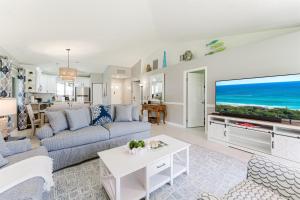 a living room with a couch and a tv at Upscale 2BR Townhome Golf, Pools & Lake Views in Palm Beach Gardens