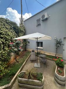 a patio with a table and an umbrella and flowers at Lavender cozy & lovely 17 in Split