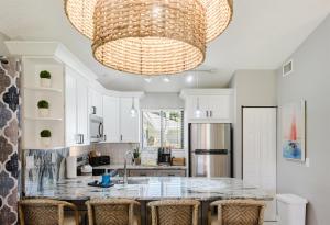 a kitchen with a chandelier and a large island at Upscale 2BR Townhome Golf, Pools & Lake Views in Palm Beach Gardens