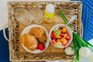 a tray with a basket of food and a bowl of fruit at Upscale 2BR Townhome Golf, Pools & Lake Views in Palm Beach Gardens