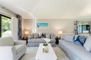 a living room with two couches and a table at Upscale 2BR Townhome Golf, Pools & Lake Views in Palm Beach Gardens