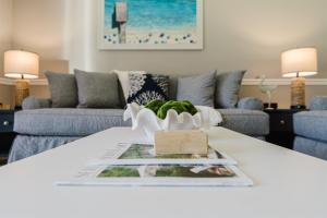 a living room with a couch and a table at Upscale 2BR Townhome Golf, Pools & Lake Views in Palm Beach Gardens +53 photos