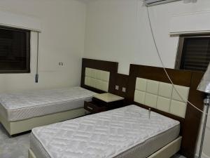 a bedroom with two beds and a window at Ahmmad Alshgoor in Şirfah