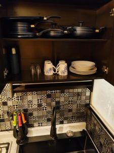 a kitchen with plates and utensils on a shelf at umbral luxury apartment in Tlajomulco +15 photos