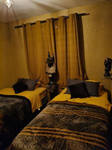 a bedroom with two beds and a window with a cat head on it at umbral luxury apartment in Tlajomulco