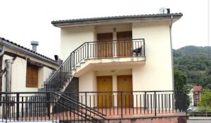 a black dog sitting on a balcony of a house at Ostatu ikaztegieta in Aldaba-chiqui