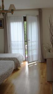 a bedroom with two beds and sliding glass doors at Ostatu ikaztegieta in Aldaba-chiqui