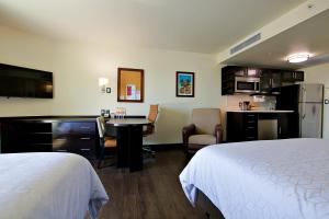 a hotel room with a bed and a desk and a kitchen at Candlewood Suites - Celaya by IHG in Celaya