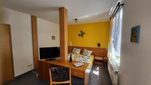 a room with a desk with a computer and a bed at Hotel & Restaurant Klosterschänke in Ruhla