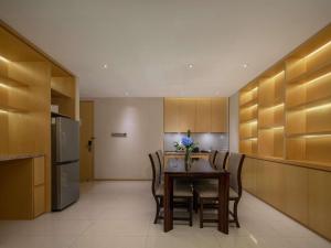 a kitchen with a table and chairs and a refrigerator at Pullman Changshu Leeman in Changshu
