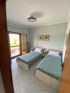 two beds sitting in a room with a window at Apostolis Seaside Living in Olympiada