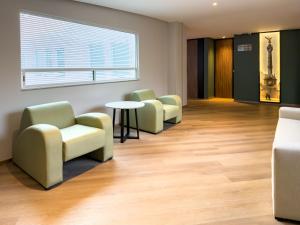 ein Wartezimmer mit Stühlen, einem Tisch und einem Fenster in der Unterkunft Hotel Via La Villa in Mexiko-Stadt