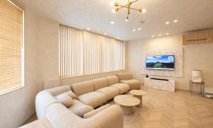 a living room with a couch and a tv at Priyado Kochi in Kochi