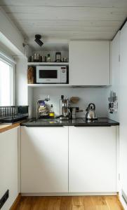 a kitchen with white cabinets and a microwave at zons22 Tiny Loft in Historic Zons - between Cologne & Düsseldorf in Dormagen +27 photos