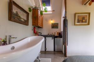a bathroom with a bath tub and a sink at The Stables in Kampen +17 photos