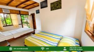 a bedroom with two beds and a window at Suites Villa Colombia in Puerto López