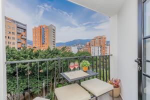 a balcony with a table and two glasses of wine at Bit Building in Medellín