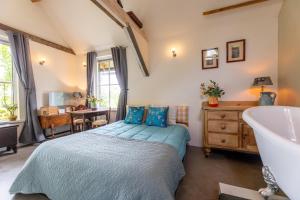 a bedroom with a bed and a tub and a sink at The Stables in Kampen