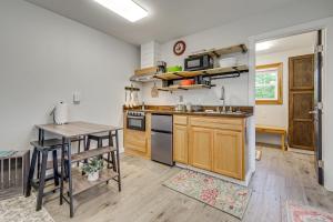 a kitchen with wooden cabinets and a table and a counter at Pet-Friendly Quaint Cottage: Park-Like Setting in Monroe