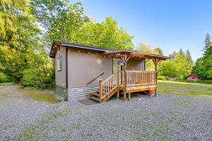 a tiny house with a porch and a deck at Pet-Friendly Quaint Cottage: Park-Like Setting in Monroe