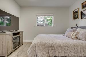 a bedroom with a bed and a flat screen tv at Pet-Friendly Quaint Cottage: Park-Like Setting in Monroe