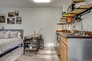 a kitchen with a sink and a couch in a room at Pet-Friendly Quaint Cottage: Park-Like Setting in Monroe +15 photos