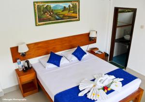 a bedroom with a large white bed with blue accents at Chillhouse Lembongan in Nusa Lembongan