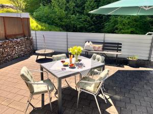 a patio with a table and chairs and an umbrella at Tiny Haus Dornbirn in Dornbirn