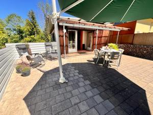 a patio with an umbrella and a table and chairs at Tiny Haus Dornbirn in Dornbirn