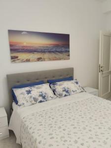 a bedroom with a bed with a painting on the wall at La Casa Bianca in Camerano