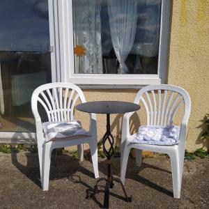 two chairs and a table in front of a window at Ferienwohnung im Krokusweg in Langenneufnach