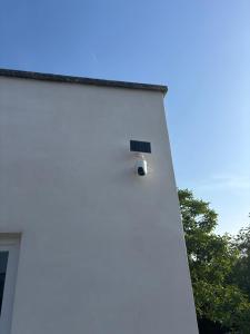 a light on the side of a white building at Maison convivial in Vireux-Wallerand