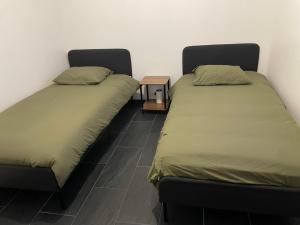 two beds sitting next to each other in a room at Maison convivial in Vireux-Wallerand